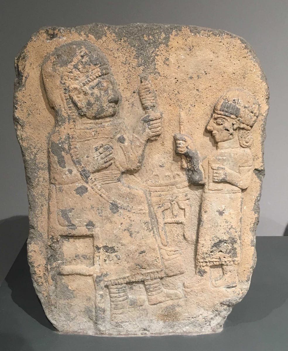 Basaltstele aus Marasch mit einer sitzenden Frau mit Spindel und einem stehenden Schreiber